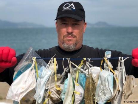 An activist from an oceans conservation group holds up surgical masks that washed up on an island near Hong Kong.